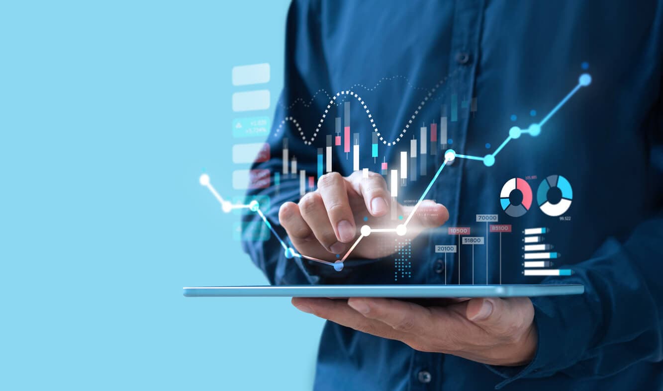 Photo d'un homme tenant une tablette affichant des graphiques de monitoring et indicateurs de performance