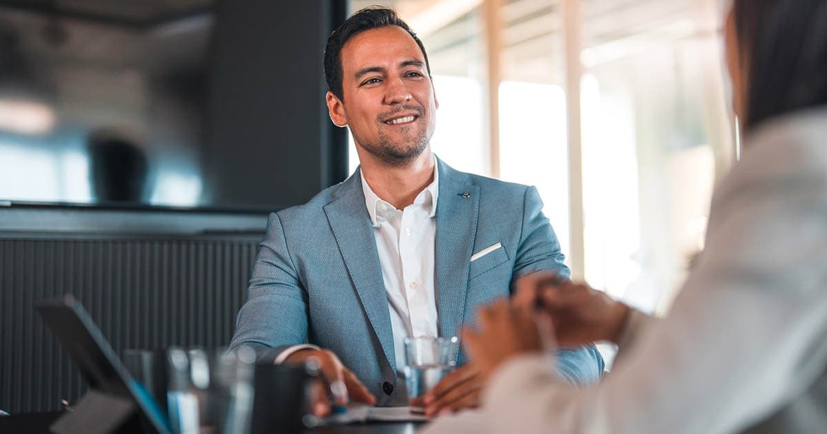 Photo d'un professionnel souriant en costume lors d'un entretien au bureau