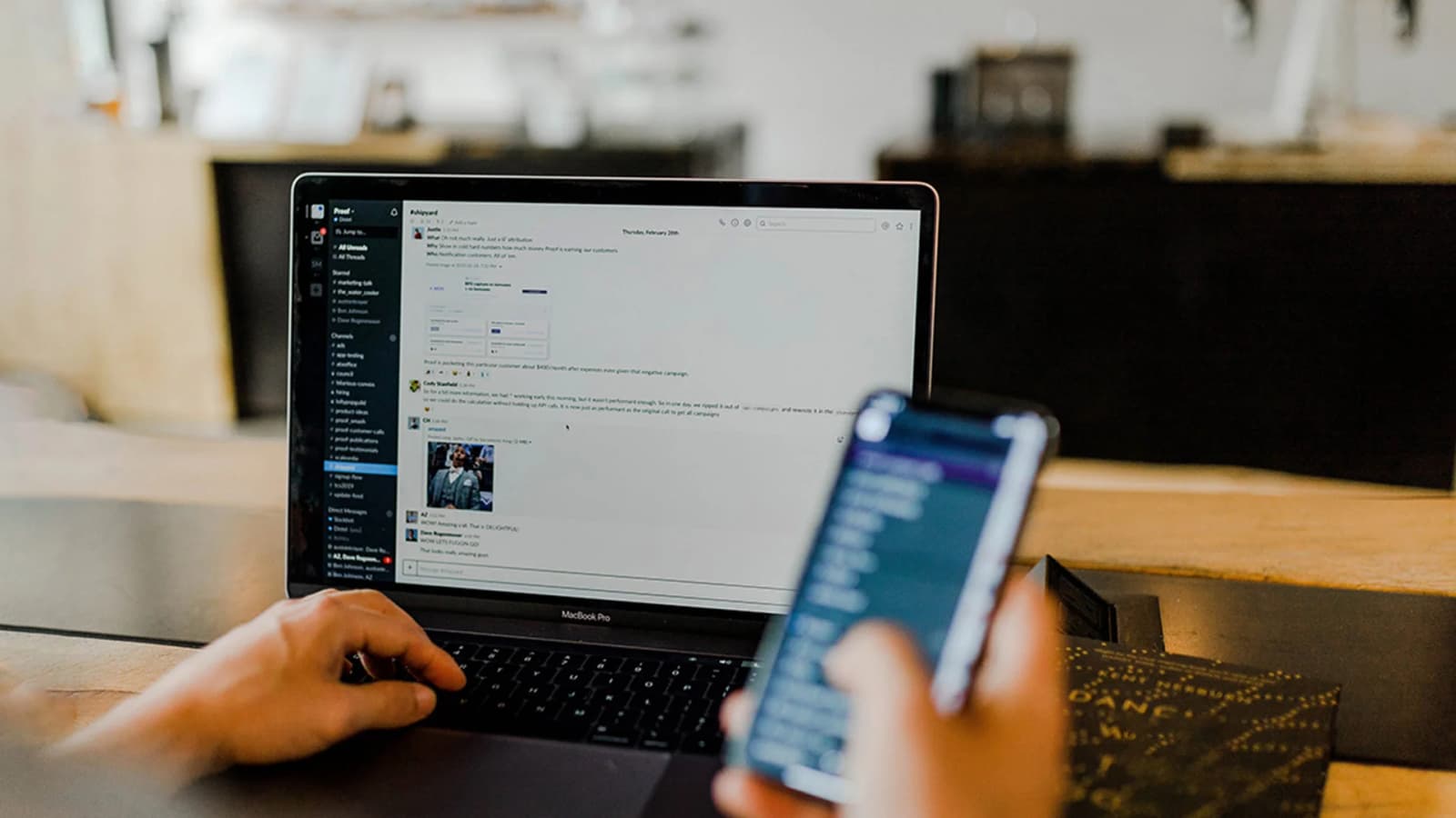 Photo d'une personne utilisant un MacBook avec une plateforme de messagerie et un smartphone