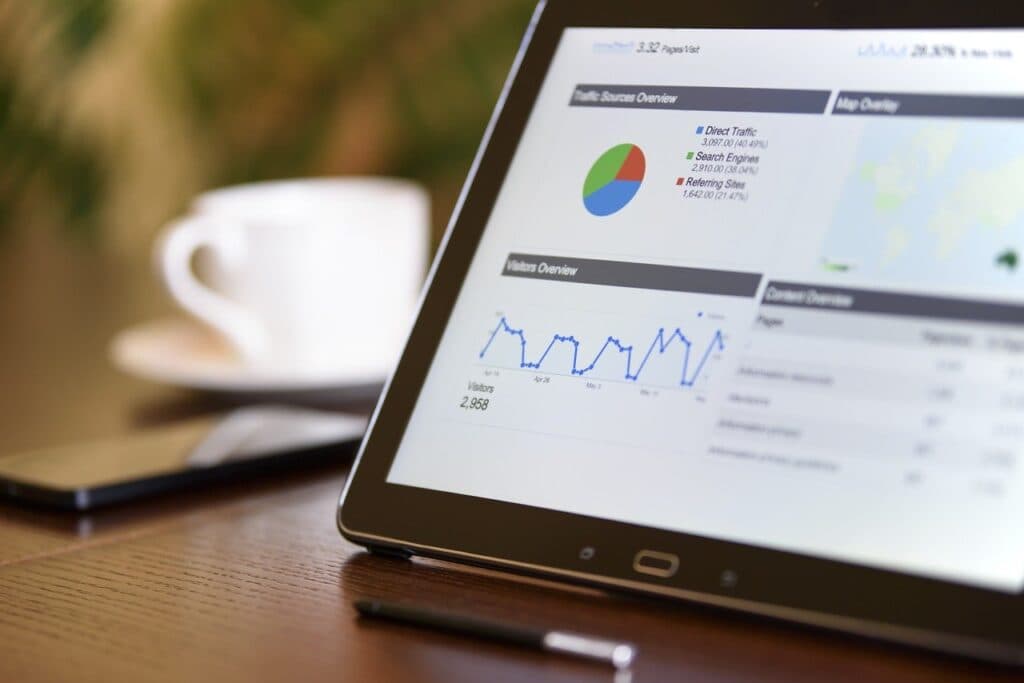 Photo d'une tablette affichant un tableau de bord analytics avec sources de trafic et graphiques