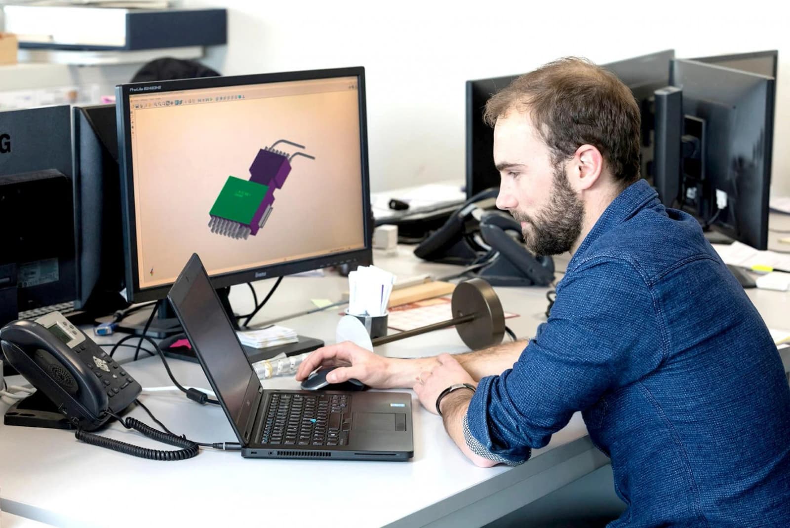 Photo d'un concepteur CAO modélisant une pièce en 3D sur son écran dans un bureau d'études