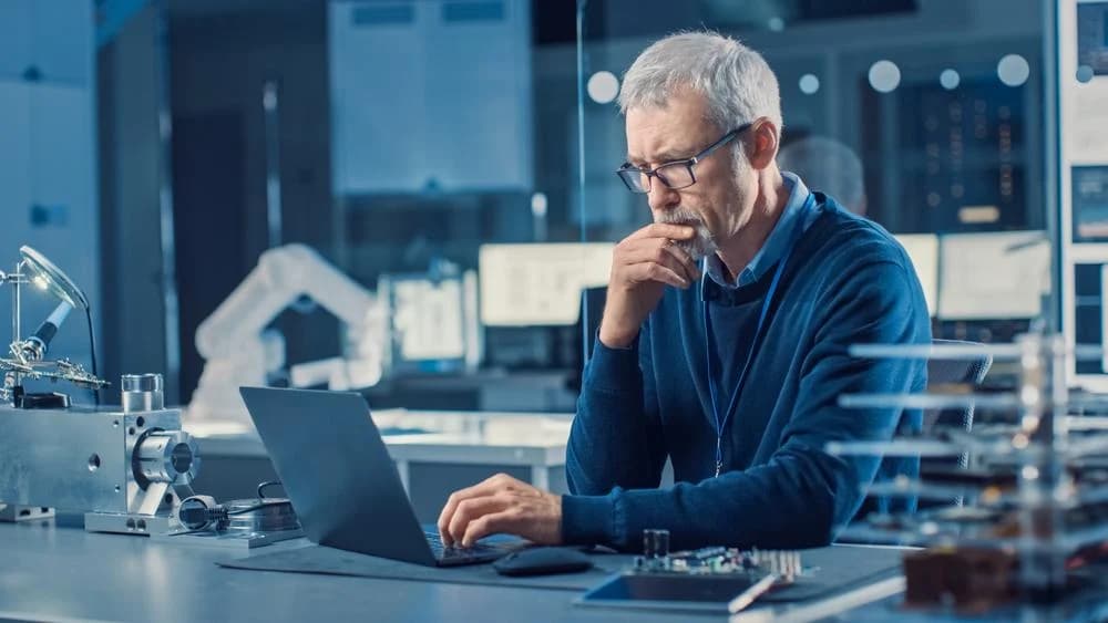 Photo d'un directeur R&D travaillant sur ordinateur dans un laboratoire de recherche high-tech