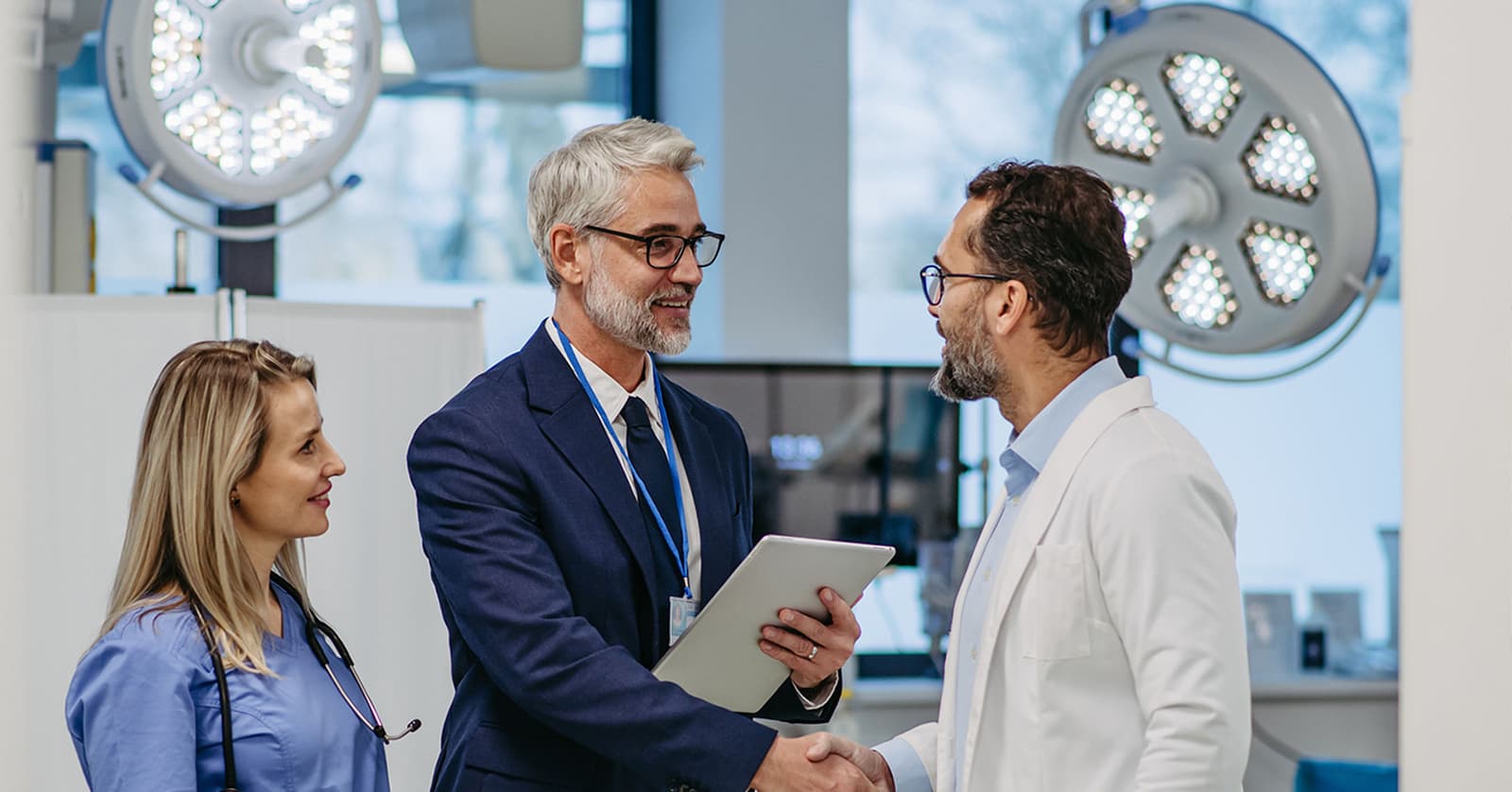 Photo de professionnels échangeant une poignée de main dans un environnement hospitalier moderne