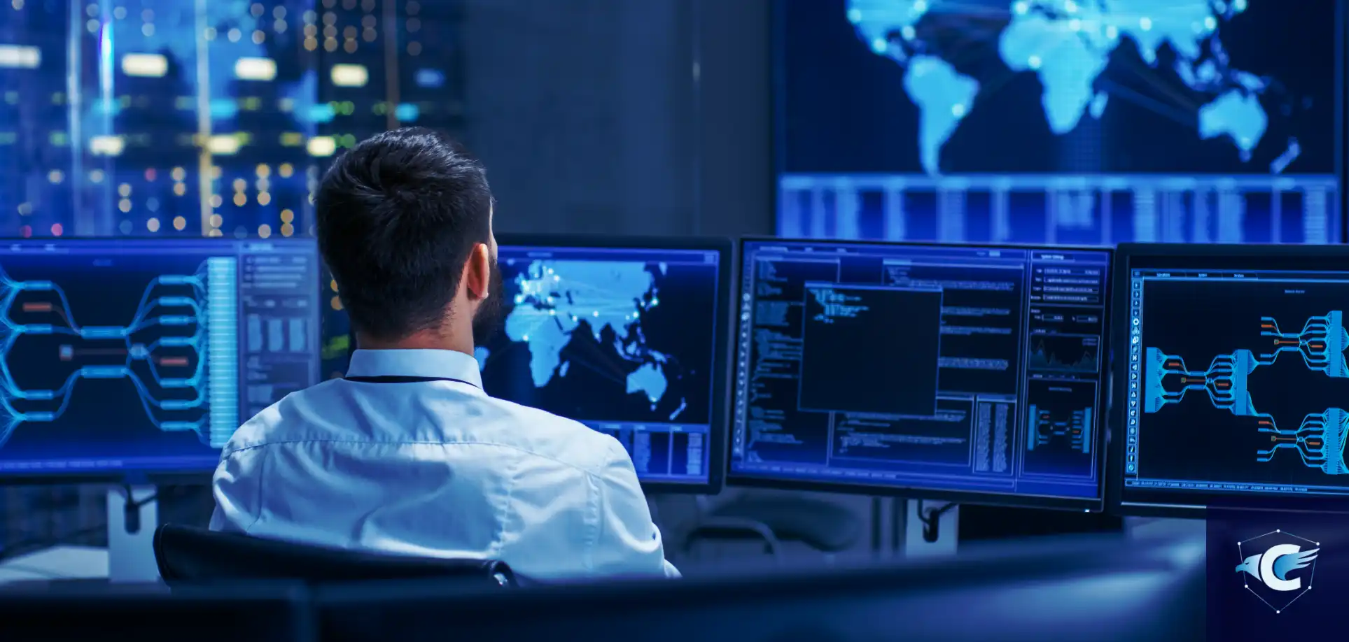 Photo d'un analyste de dos surveillant plusieurs écrans dans un centre de sécurité informatique